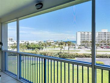 View from a screened balcony overlooking lush landscaping and ocean at 5300 S Atlantic Ave # 3-405, New Smyrna Beach, FL 32169