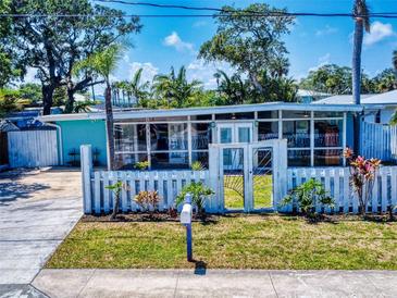 Charming home featuring a white picket fence, well-manicured lawn, and light blue exterior at 650 S Pine St, New Smyrna Beach, FL 32169