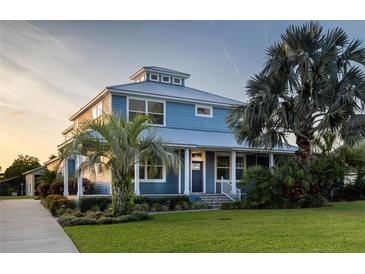 Stunning two-story home with metal roof, lush landscaping, and a charming covered porch at 1787 Earhart Ct, Port Orange, FL 32128