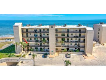 Condo building with ocean view, balconies, palm trees, and parking in front at 2222 Ocean Shore Blvd # 201B, Ormond Beach, FL 32176