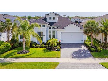 Charming one-story home boasts beautiful landscaping, brick driveway, and a two-car garage at 6277 W Fallsgrove Ln, Port Orange, FL 32128
