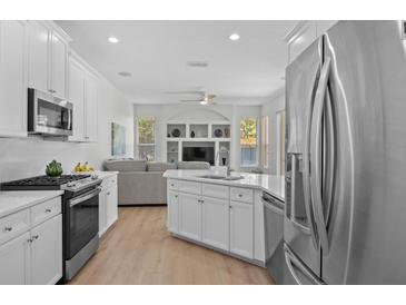 Bright kitchen featuring white cabinetry, stainless steel appliances and an island with a sink at 11222 Rapallo Ln, Windermere, FL 34786