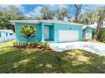 Charming blue single-story home with a bright white garage door and a well-manicured front yard at 1209 Palmetto St, New Smyrna Beach, FL 32168