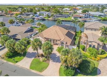 Beautiful waterfront home with a brick driveway, lush landscaping, and gorgeous canal views at 133 Via Capri, New Smyrna Beach, FL 32169