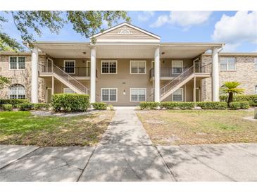 Inviting condo building features a manicured lawn and exterior stairs to the second-floor units at 160 Reserve Cir # 204, Oviedo, FL 32765