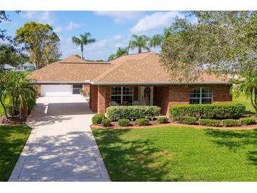 Charming single-story brick home with a well-manicured lawn and mature landscaping at 1688 Town Park Dr, Port Orange, FL 32129