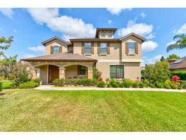 Charming two-story home featuring manicured lawn and landscaping with a welcoming front porch at 1703 Frogs Leap Ct, Port Orange, FL 32128