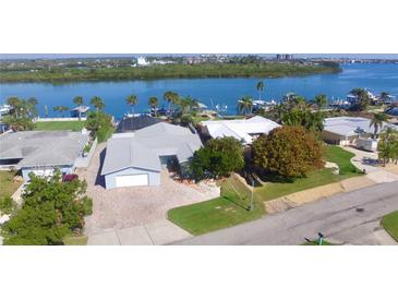 Waterfront home featuring beautiful landscaping, paver driveway, and stunning water views at 34 Richmond Dr, New Smyrna Beach, FL 32169