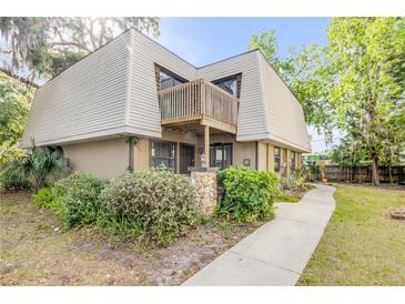 Two-story home featuring a quaint balcony, stone accents, and charming landscaping at 3656 Jackson St # 11, Port Orange, FL 32129