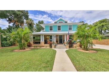 Charming two-story home with well-manicured lawn and inviting front porch with traditional landscaping at 508 Faulkner St, New Smyrna Beach, FL 32168