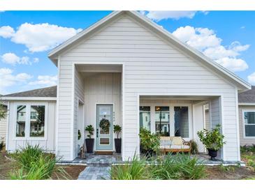 Charming home featuring a covered porch, light blue door, beautifully landscaped front yard and striking architectural details at 6542 Rover Way, St Cloud, FL 34771
