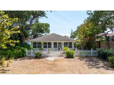 Charming single-story home featuring a white picket fence and lush landscaping at 825 E 23Rd Ave, New Smyrna Beach, FL 32169