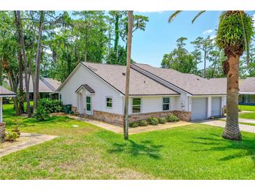 Charming single-story home featuring a well-maintained lawn, brick accents, and an attached single-car garage at 115 Bob White Ct, Daytona Beach, FL 32119