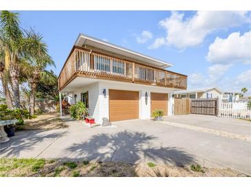 Two-story home features a double garage, a second-story patio and tropical landscaping at 2510 S Atlantic Ave, New Smyrna Beach, FL 32169