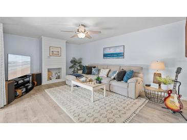 Bright living room with modern decor, ceiling fan and fireplace at 3808 Saxon Dr, New Smyrna Beach, FL 32169