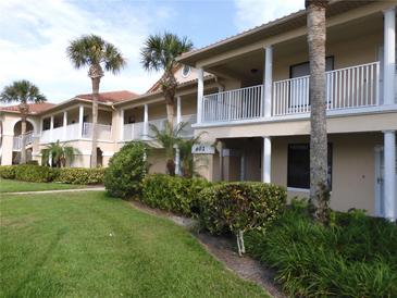 Charming condos with white railings, lush landscaping, and palm trees create a welcoming community atmosphere at 402 Bouchelle Dr # 205, New Smyrna Beach, FL 32169