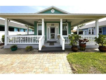 Charming home featuring a spacious covered front porch with white railings and decorative potted plants at 415 Jessamine Ave, New Smyrna Beach, FL 32169