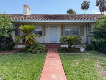 Charming single-story home featuring mature landscaping, a red-tiled roof, and inviting curb appeal at 5018 Riverside Dr, Port Orange, FL 32127