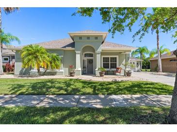 Charming single-story home with lush landscaping, a well-manicured lawn and beautiful tropical palm trees at 637 Marisol Dr, New Smyrna Beach, FL 32168