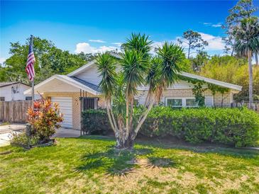 Charming single-story home featuring a well-manicured lawn, landscaping, and an attached garage at 830 Christy Dr, Port Orange, FL 32129