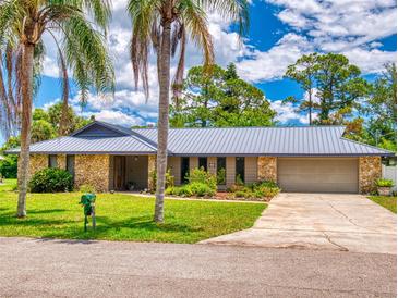 Charming home featuring a stone facade, metal roof, and well-manicured landscaping at 108 Dee St, New Smyrna Beach, FL 32168