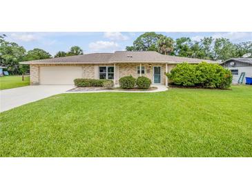Charming one-story brick home with a well-manicured lawn and inviting curb appeal at 125 Orange Ave, Edgewater, FL 32132