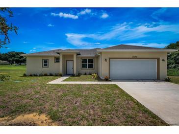 Charming single-story home showcasing a manicured lawn and attached two-car garage at 15190 Cr-565A, Clermont, FL 34711