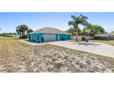 A quaint turquoise home featuring an attached garage, neat front yard, and a long driveway at 1845 Willow Oak Dr, Edgewater, FL 32141