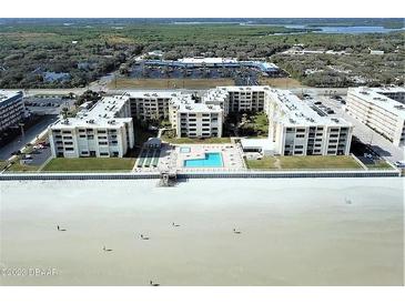 An aerial view of the Castle Reef Condominiums and the nearby beach, and community pool at 4175 S Atlantic Ave # 2280, New Smyrna Beach, FL 32169