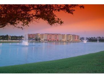 Beautiful waterfront community with fountains and lush green lawn against a colorful sunset sky at 424 Luna Bella Ln # 316, New Smyrna Beach, FL 32168
