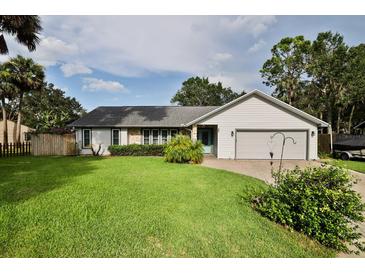 Charming single-story home featuring a manicured lawn, stone accents, and an attached two-car garage at 475 Spruceview Dr, Port Orange, FL 32127
