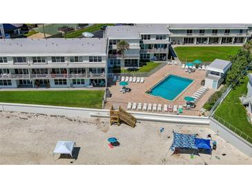 Aerial view of beachfront condo complex with pool, beach access, and well-maintained green spaces at 4849 Saxon # C202, New Smyrna Beach, FL 32169