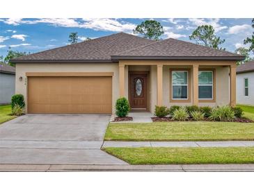 Inviting single-story home with a two-car garage, manicured lawn, and a charming entryway at 534 Stowers Dr, New Smyrna Beach, FL 32168