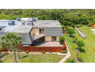 Overhead view of the home with a patio area, lawn and mature landscaping at 94 Cedar Dunes Dr, New Smyrna Beach, FL 32169