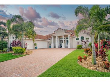 Beautiful home featuring manicured landscaping, tile roof, brick drive, and a three-car garage at 150 Portofino Blvd, New Smyrna Beach, FL 32168