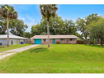 Charming single-story home featuring a well-maintained lawn and brick accents at 1723 Needle Palm Dr, Edgewater, FL 32132
