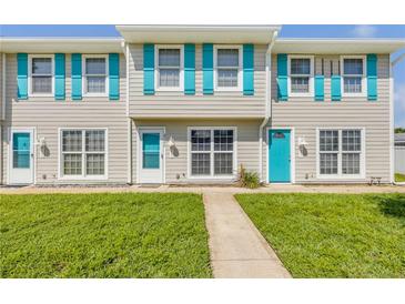 Inviting townhome featuring a tidy lawn, charming blue shutters, and a well-maintained facade at 2122 S Atlantic Ave # 2122, New Smyrna Beach, FL 32169