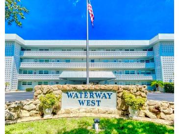 Waterway West building features an American flag, manicured grounds, and is conveniently located near shopping and amenities at 315 N Causeway # 2060, New Smyrna Beach, FL 32169