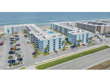 Beautiful aerial view of beachside condos with a community pool, parking, and ocean views at 4151 S Atlantic Ave # 3090, New Smyrna Beach, FL 32169