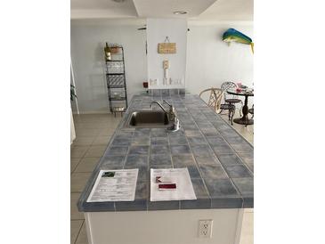 Kitchen island featuring a sink with tile countertop, and decor at 5201 S Atlantic Ave # 407A, New Smyrna Beach, FL 32169