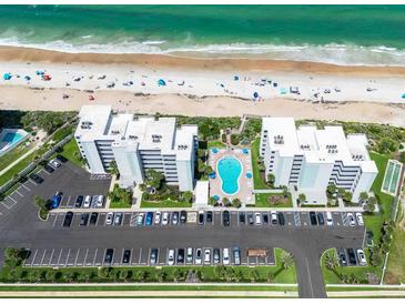 An aerial view of a beachfront condo community with a pool, parking, and easy beach access at 5301 S Atlantic Ave # 140, New Smyrna Beach, FL 32169
