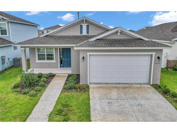 Charming single-story home with a two-car garage, blue door, and well-maintained landscaping at 7223 Sw 61St Pl, Ocala, FL 34474