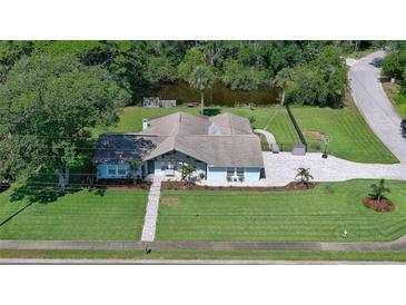 Beautiful single-story home featuring an expansive, well-maintained lawn and attractive landscaping near a tranquil pond at 798 Fairway Dr, New Smyrna Beach, FL 32168