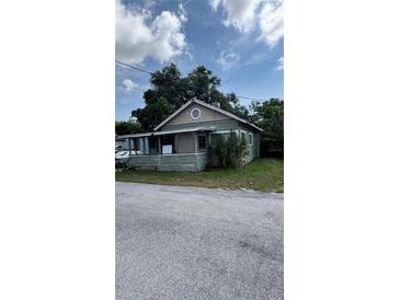 Charming one-story home featuring a covered front porch and mature landscaping at 215 Alma Ct, New Smyrna Beach, FL 32168