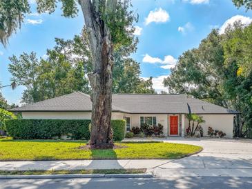 Well maintained single story home featuring a red front door, mature landscaping, and a lush green lawn at 2338 Tuscarora Trl, Maitland, FL 32751