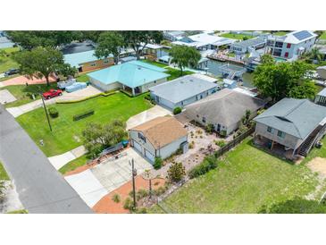 This aerial view shows the proximity to the water, as well as multiple buildings and lush green grass at 235 Randle Ave, Oak Hill, FL 32759