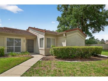 Inviting single-story home with a lush front lawn, complemented by a charming walkway to the front door at 258 W Sabal Palm Pl # 22, Longwood, FL 32779