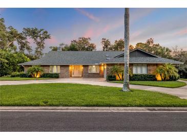 Charming brick home with mature landscaping, well-manicured lawn, and long driveway at 544 Bottlebrush Ct, New Smyrna Beach, FL 32168