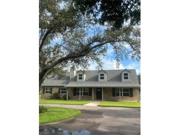 Charming one-story home with light brick, mature trees, black shutters, and inviting curb appeal at 5832 Michelle Ln, Sanford, FL 32771