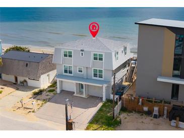 Coastal two-story home featuring a light grey exterior with beach access and a two-car garage at 6883 S Atlantic Ave, New Smyrna Beach, FL 32169